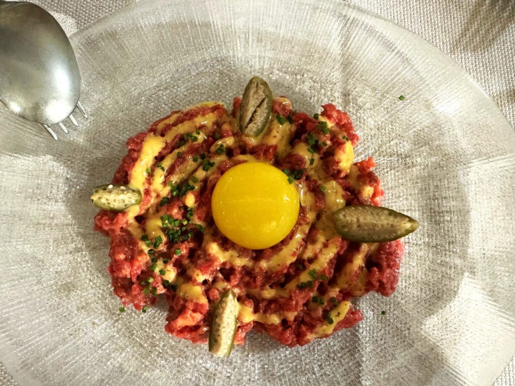 Steak tartare at La Cosmopolita Málaga with egg yolk and pickles