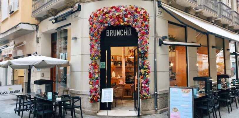 Brunchit Málaga Eingang mit bunter Blumenfassade im Stadtzentrum - beste Brunch-Location in Málaga