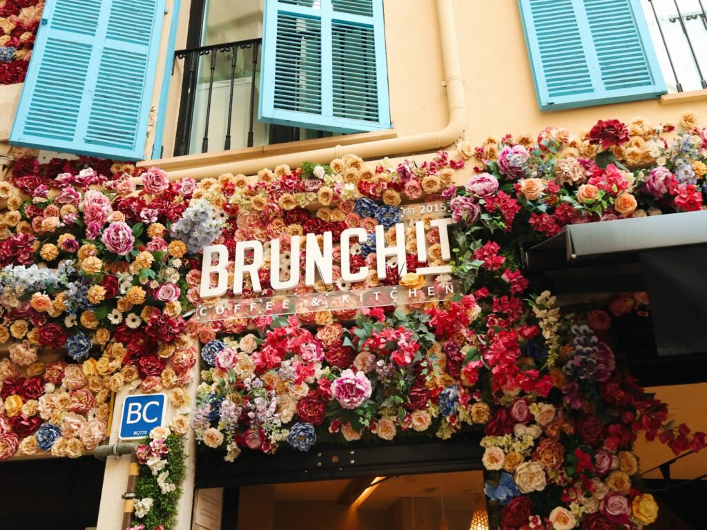Brunchit Málaga flower facade with colorful floral entrance and sign – best brunch Málaga café