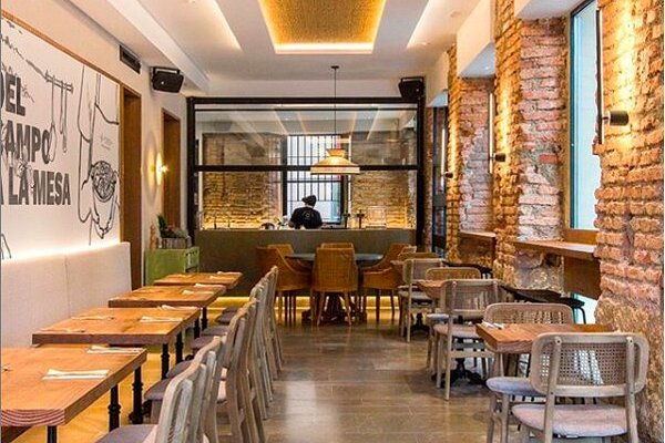 BYOKO Málaga interior with modern wooden tables and cozy seating – healthy brunch café Málaga