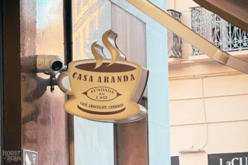 Casa Aranda Málaga-skylt med kaffekopplogotyp på gatan i Gamla stan