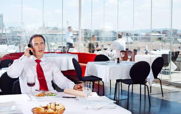 Businessman having lunch and making a call in a chic restaurant