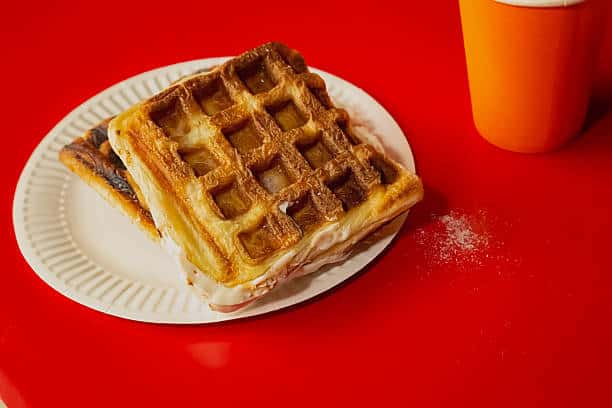Close-up of a plate with Belgian waffles against a red background
