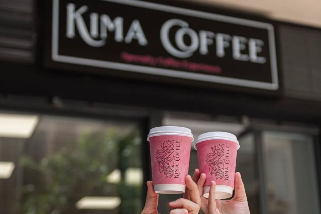 Takeaway coffee cups from Kima Coffee Málaga in front of the café