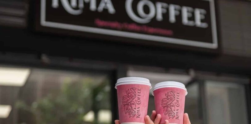Kaffeebecher zum Mitnehmen von Kima Coffee Málaga vor dem Café