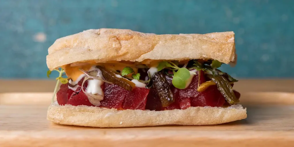 Gourmet sandwich at La Cosmopolita Málaga with tuna, vegetables and creamy sauce