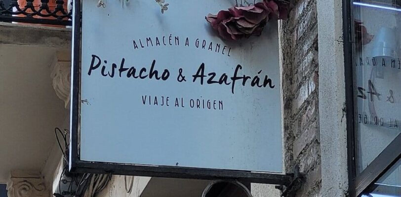 Restaurantschild Pistacho & Azafrán Málaga mit Blumendekoration