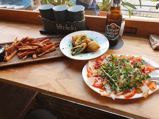 Recyclo Bike Café Málaga brunch dishes with salad, fries and tapas