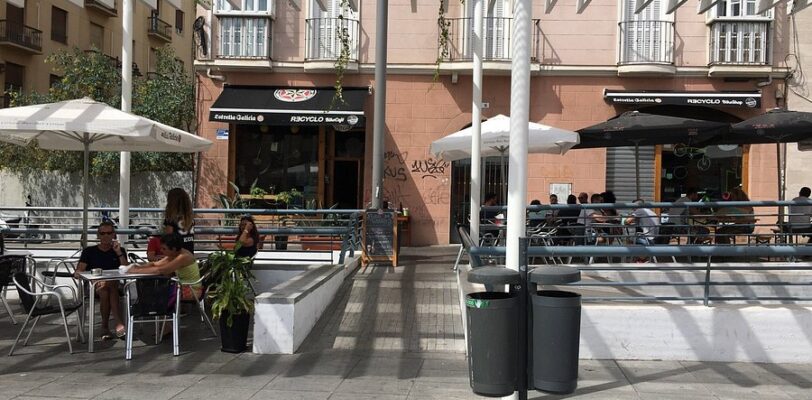 Außenterrasse des Recyclo Bike Café Málaga mit Kunden, die den Brunch genießen