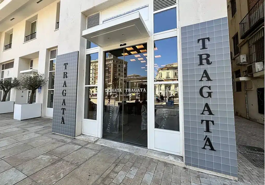 Eingang des Restaurants Tragatá Málaga mit moderner, minimalistischer Fassade